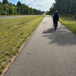Jill rides ahead on the trail just outside Lake Bemidji Stsre Park