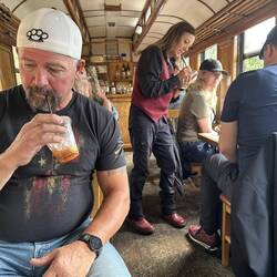Car host Kathy takes a cocktail order while Mike, seated with his wife at my table, finishes his