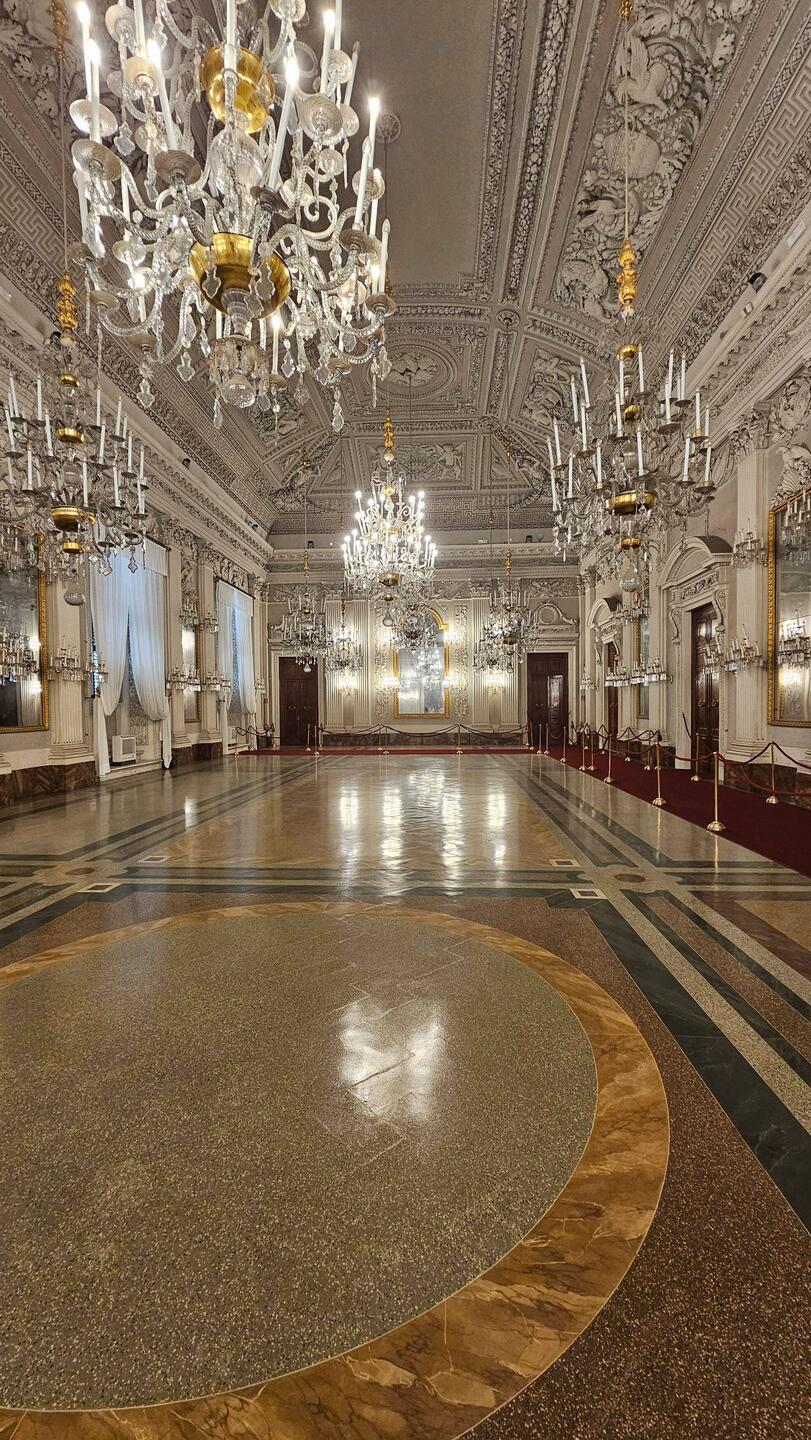 The Grand ballroom! So many chandeliers! Only a couple are lit. Walls also covered by candelabra!