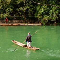 Ein Parkwächter serzt über den Fluss