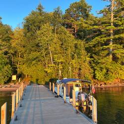Setting sun shining on Basswood Island in front of C-Traveler