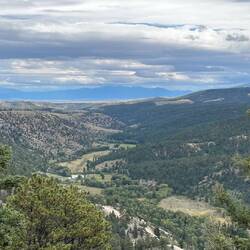 The taupe-coloured Cañon Bonito Valley in the far distance, with the Sangre de Cristo Range beyond