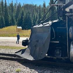 The train at Cumbres. The highway sign announces "Cumbres Pass Summit, 10,022 ft".
