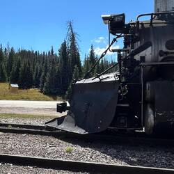 The train at Cumbres. The highway sign announces "Cumbres Pass Summit, 10,022 ft".