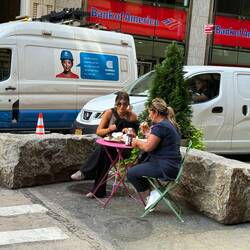 Die Damen sitzen mitten an d. WallStreet zwischen den Autos😅