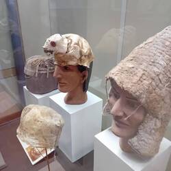 This high class man wears a furry hat decorated by the skull of the fur owner