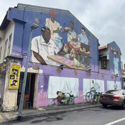 This mural depicts, among other things, a man making shaved ice, another making a garland.