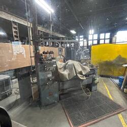 A passenger car is being renovated inside the roundhouse