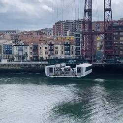 Sorprende su góndola colgante transportando personas y coches sobre el Nervión.