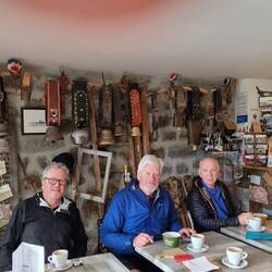 3 old guys enjoying the rest. Giant cow bells behind