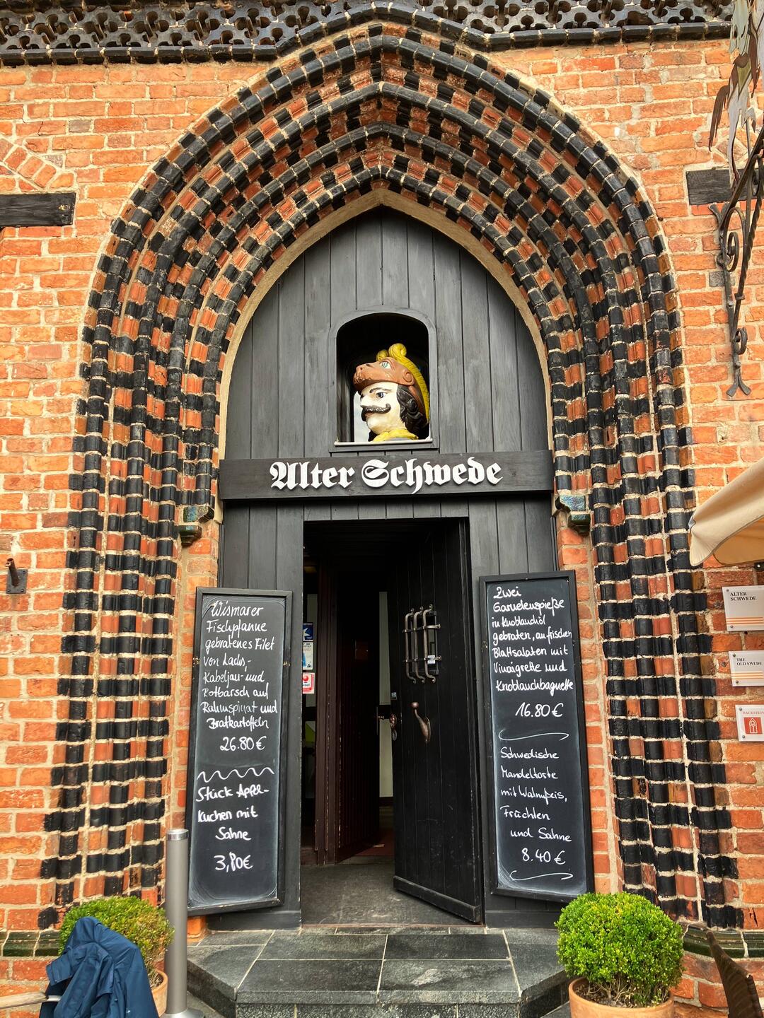 Eingang zum Gasthaus "Alter Schwede" mit holzgeschnitztem Soldatenkopf