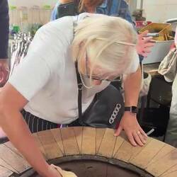 Placing the bread on the wall of the tandoori oven
