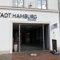 Hier wurde eine Strasse überbaut, Durchgang steht noch und Strassenschild darüber