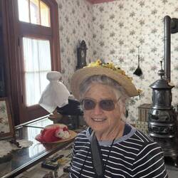 Jill tries on a hat in the Millenary Shop.
