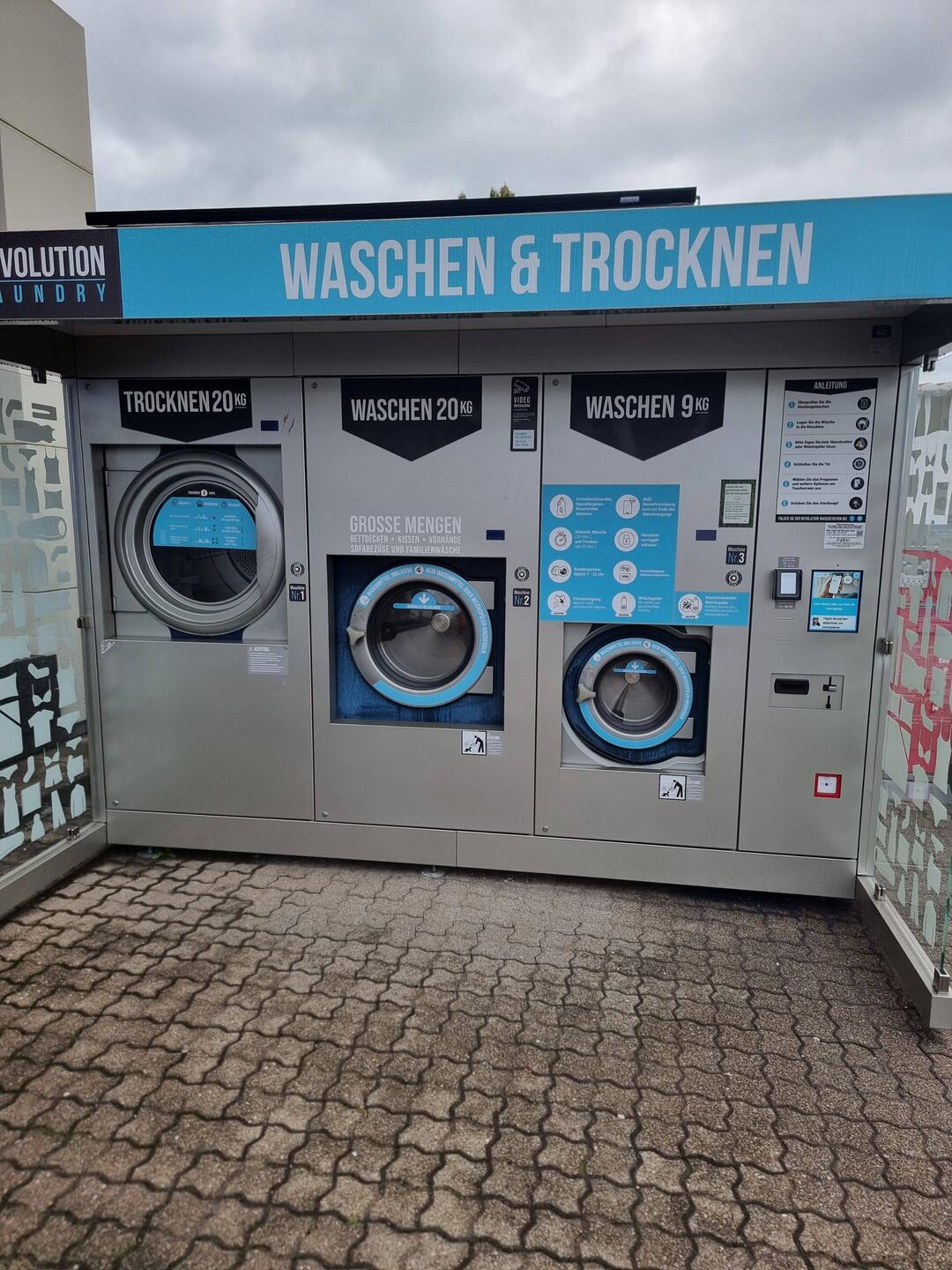 Drei Waschmaschinen an einer Tankstelle