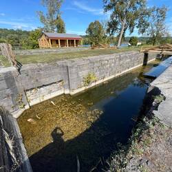 Along with the view of the lock, you can see the current Erie Canal (Mohawk River) behind the trees
