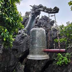 ein Drachenkopf 🐲, der aus dem Felsen ragt, hält die Bronzeglocke 🔔