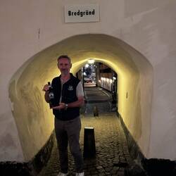 Handsome Man Holding Wine in a Tiny Tunnel