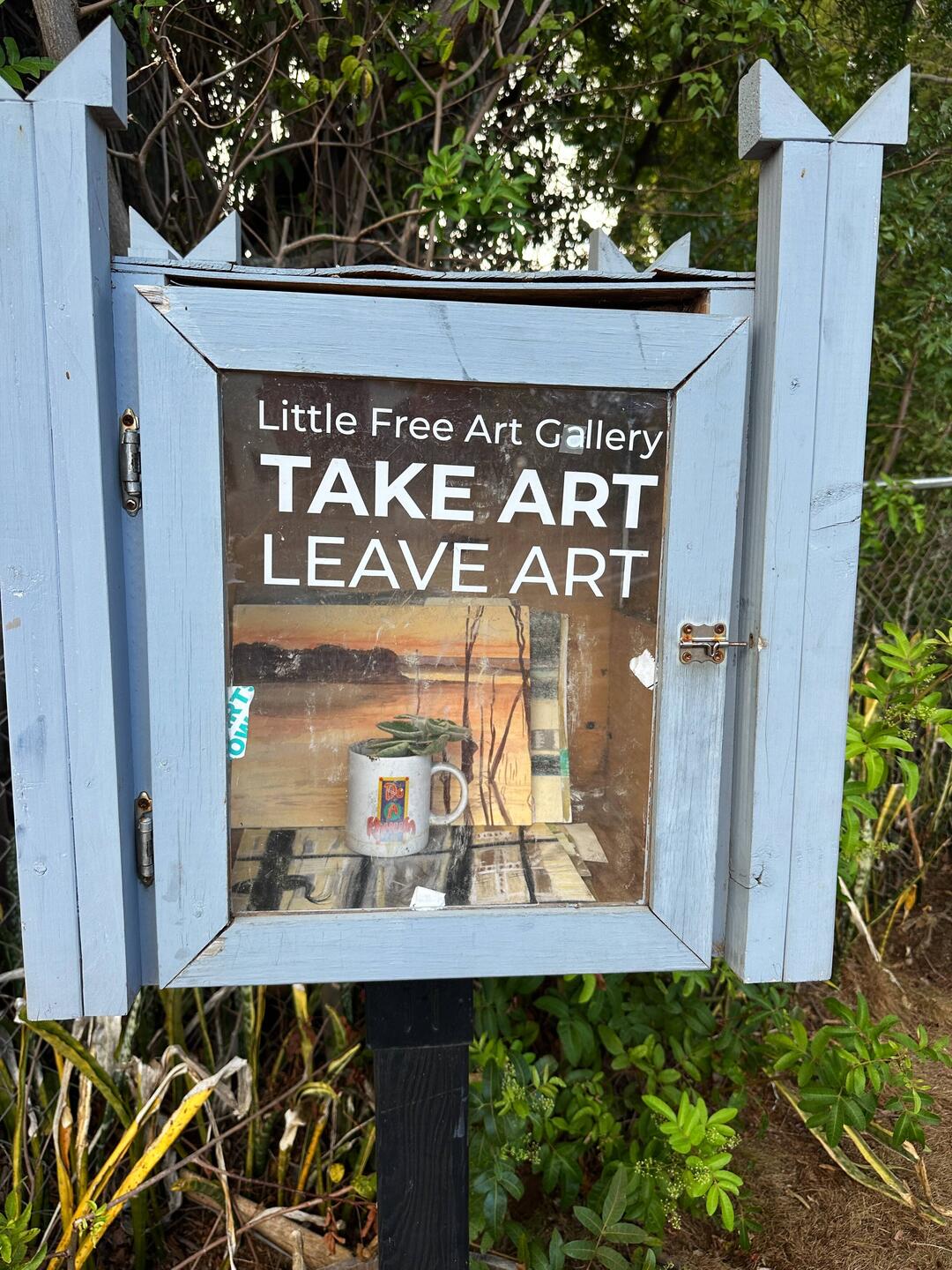 The "Take Art, Leave Art" booth outside the public library at Makawao.