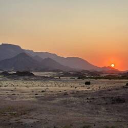 Die Sonne geht hinter dem Brandbergmassiv unter