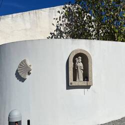 Signs of Camino and a pilgrim. Beside the pilgrim is a self-stamp