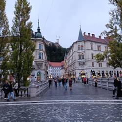 An evening walk into Ljubljana with bridge over the river and the castle on the hill