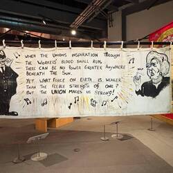 Solidarity Forever lyrics on the back of a "lesbians and gays support the miners" banner