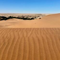 hier gut zu erkennen: Im Vordergrund die Dünen und hinter dem grünen Flusstal die Geröllwüste
