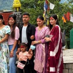 Family posing for pictures at the temple with their "tika" blessing on the forehead