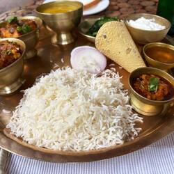 Traditional Nepali meal-thali with lentils, rice, vegetables, greens, yogurt, sometimes meat