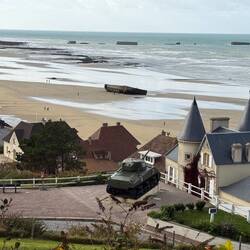 Town of Arromanches. Sherman tank and remains of Port Winston on the beach and in the water