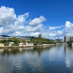 Crossing the bridge with the Hiroshima Memorial Peace Museum ahead.