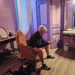 Lee writing his blog on the armchair in their bathroom!