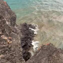 Die Wellen schlagen gegen die Felsen, während Nebel die Berge am Chilko Lake verhüllt.