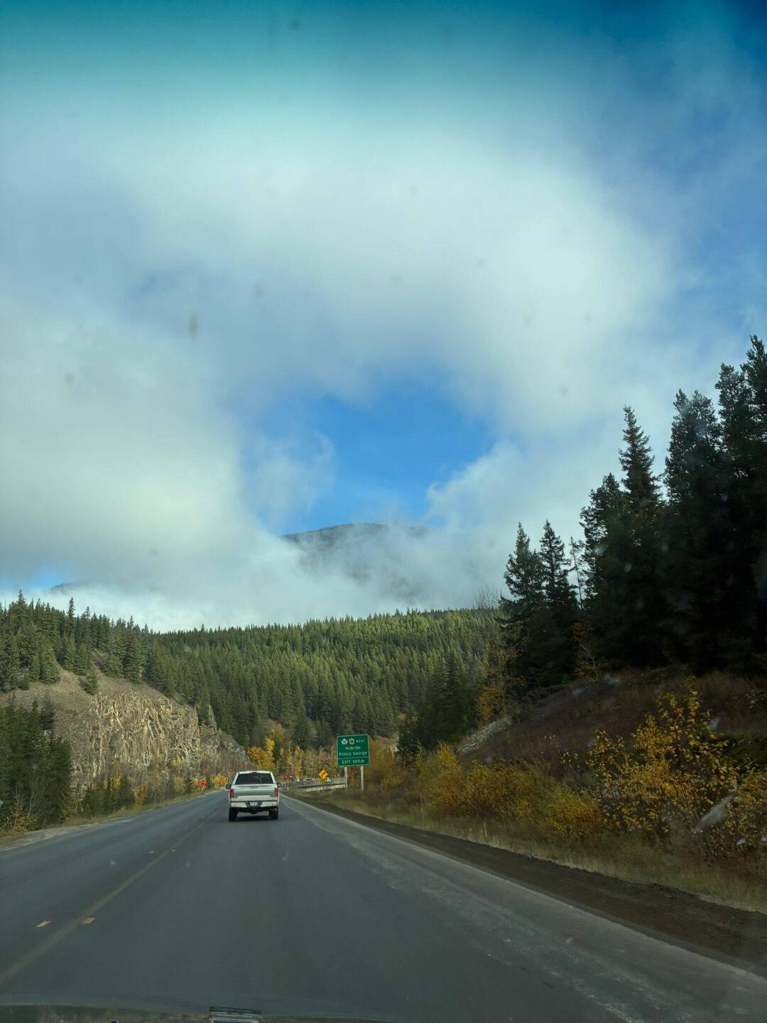 Die Wolken lichten sich und geben den Blick auf die ersten Berggipfel frei.