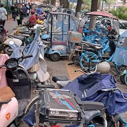 Mopeds & bikes are popular modes of transport, parked all over sidewalks.