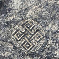 In den Fels gemeißelt: ein verschlungenes Symbol, das still von alten Wegen und Geschichten erzählt.
