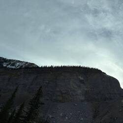 Ein schmaler Streifen Wald krönt den Fels.