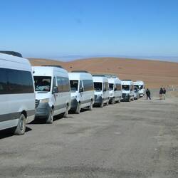 Auf der anderen Seite der Grenze steht eine Kolonne Sprinter, die ihre Touristen ausgeladen haben.