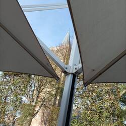 Blick zwischen den Sonnenschirmen auf den Kirchturm