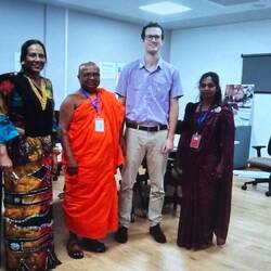 Aiden between his Buddhist monk principal and his co-teacher.