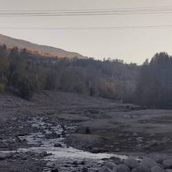 A man prays his Duhr next to the creek.
