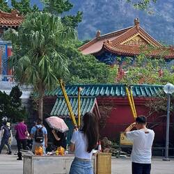Young people praying to the temple with incense offerings.