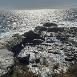 Heavily eroded rocks below lighthouse