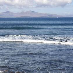 Surfer warten auf die richtige Welle. Im Hintergrund wartet Lanzarote auf mich.