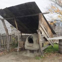 Mud oven is shelterd to keep it from melting in the rain.