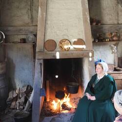 "Pilgrim woman" by the cooking fire in another house.
