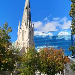 Alte Kirche vor modernem Hochhaus