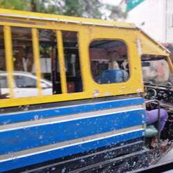 Some sort of public tuk tuk...those are bars not windows