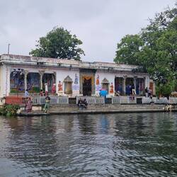 A temple in the water .one lady was in the water ,another having facial washing